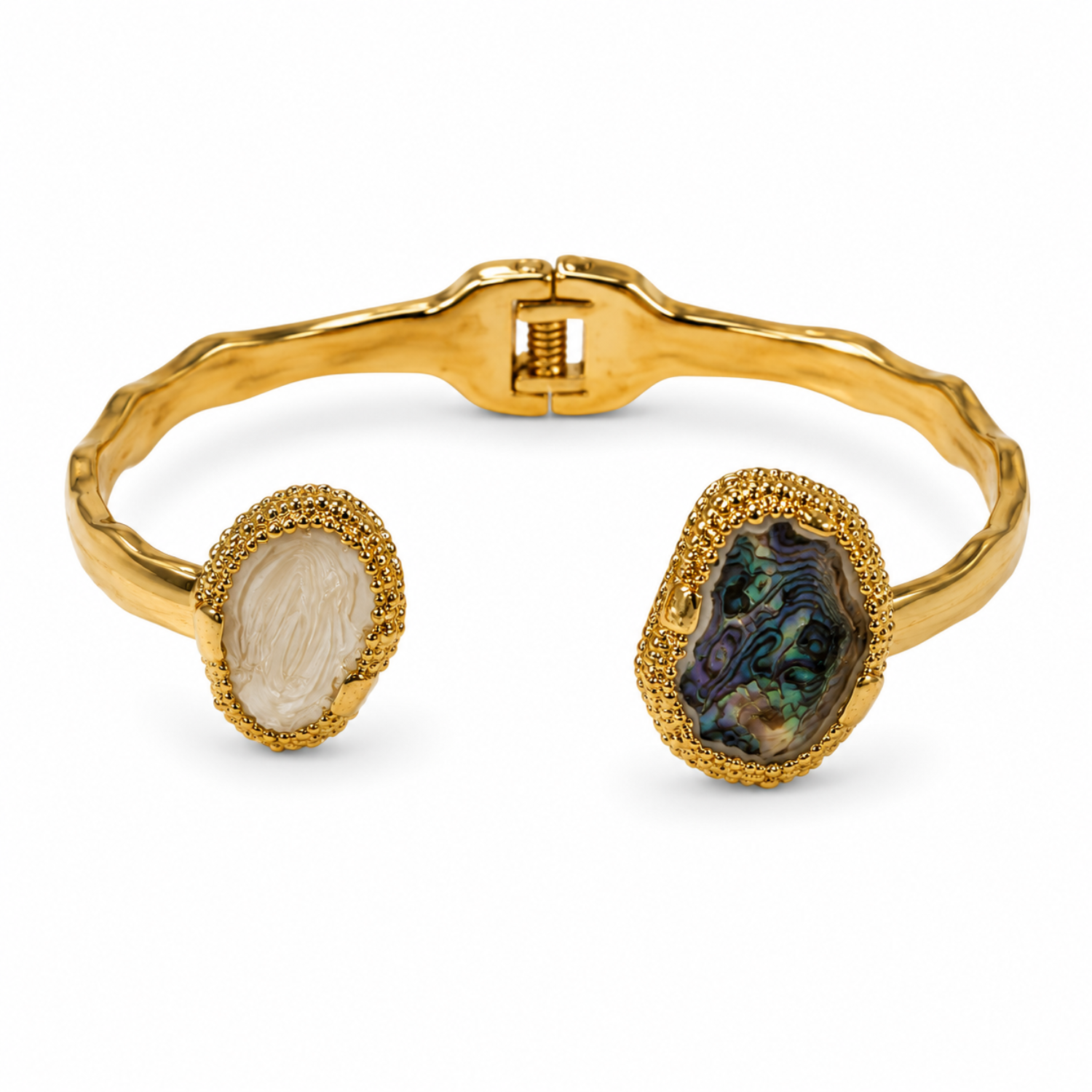 A gold-tone open cuff bracelet featuring two large natural abalone shell inlays, one milky white on the left and one iridescent green-blue on the right, set in textured gold bezels on a white background.