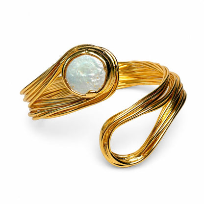 A gold wrap ring featuring a round, textured white opal stone in a bezel setting, photographed on a clean white background.
